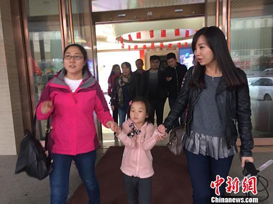 爷爷奶奶爸爸妈妈均去世 7岁小女孩无家可回 图为郑州市陇海医院的工作人员送王金丽去市儿童福利院 。 王秋兰 摄